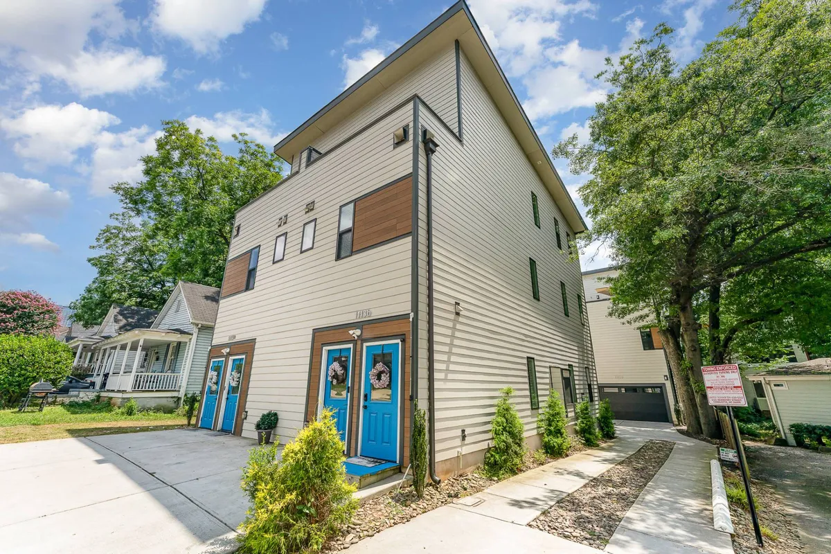Another exterior view showcasing vibrant blue doors, modern architectural lines, and lush greenery. The image suggests ease of arrival and ample outdoor space.